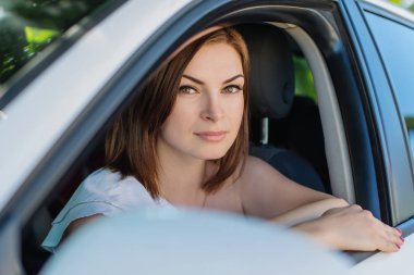 Araba pencereden dışarı bakarak ve gülümseyen genç kadın portresi