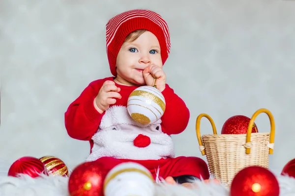 ボールの装飾クリスマス ツリーとサンタさんのヘルパーとして服を着た赤ちゃんの肖像画 — ストック写真