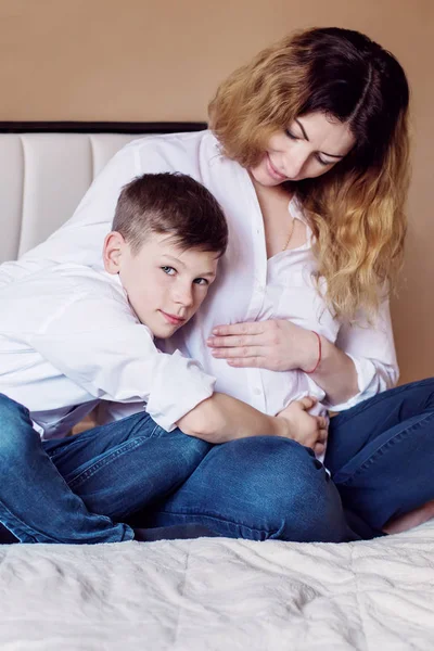 Mutlu Oğul Yatakta Oturmuş Hamile Anne Karnına Dokunur — Stok fotoğraf