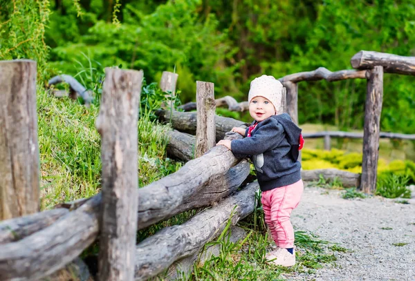 都市の外の公園に木の塀に立って愛らしい幼児の赤ちゃん女の子 — ストック写真