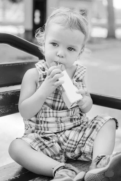 Pequeno Bebê Bonito Beber Suco Uma Palha Enquanto Sentado Banco — Fotografia de Stock