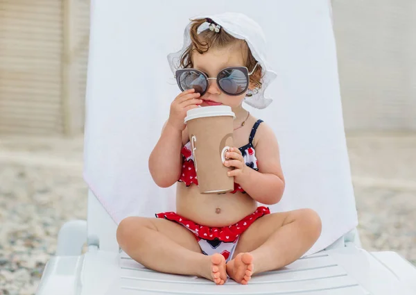 Niña Feliz Sentada Una Tumbona Con Gafas Sol Sosteniendo Una — Foto de Stock