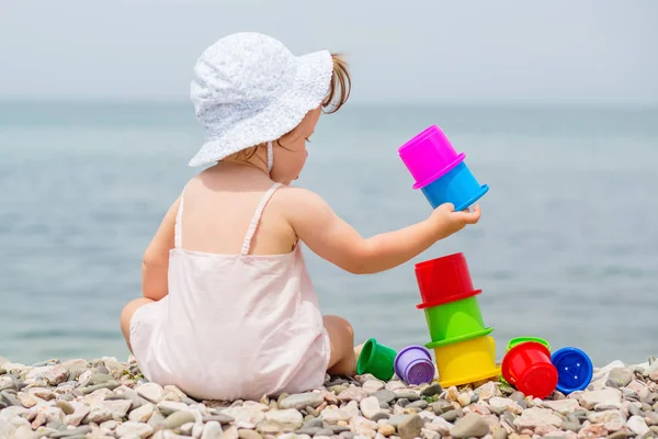 かわいい幼児の女の子がビーチでカラフルなおもちゃで遊んで — ストック写真