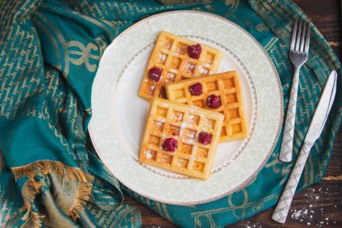 Beyaz tabakta ahududu ile servis edilen waffle 'lar. Üst Manzara. yumuşak odak