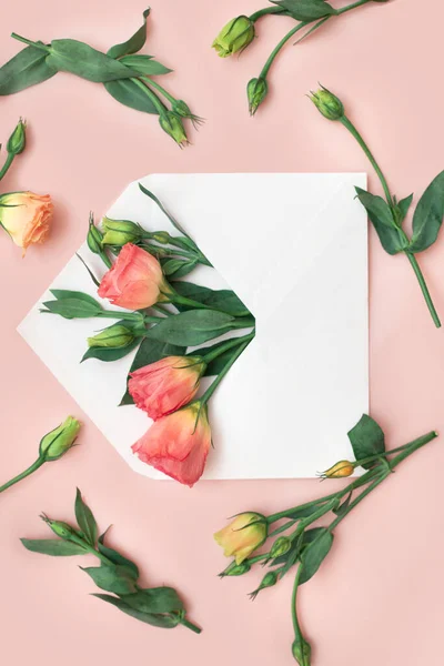 Otevřená obálka s eustomou květiny uspořádání na růžovém pozadí, horní pohled. Slavnostní uvítací koncept. Vetrické Stock Obrázky