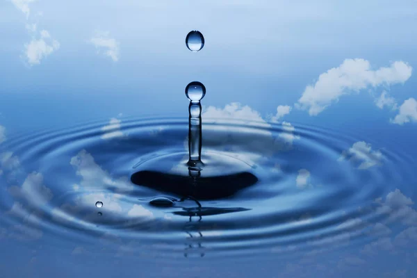 Splash Krople Okrągłe Deszczu Spadające Gładkiej Powierzchni Wody Błękitne Niebo — Zdjęcie stockowe