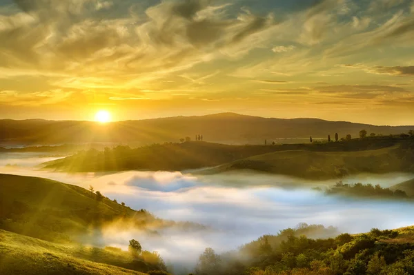 İtalyan güzel manzara, Tuscany sisli haddeleme alanlarında yükselen güneş ışığında