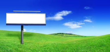Yeşil alanlar, mavi gökyüzü ve arka plan beyaz bulutlar arasında boş billboard