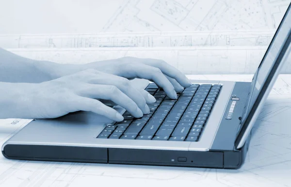 Female Hands Laptop Keyboard Architectural Plans Background Blue Tint — Stock Photo, Image