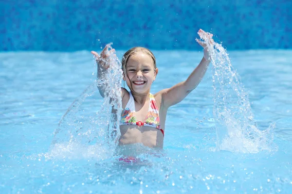 可爱的女孩游泳和玩在蓝色水在游泳池 — 图库照片