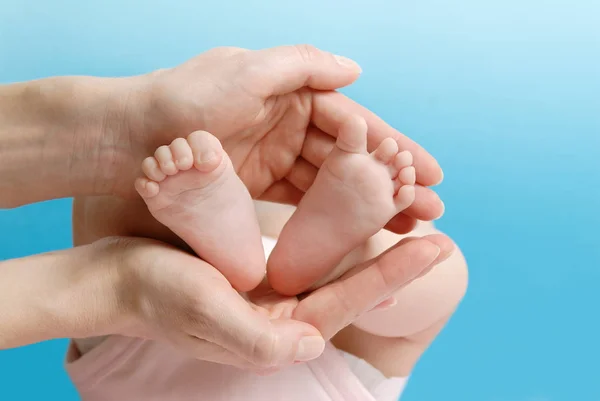 手持小婴儿脚的女性手掌 — 图库照片