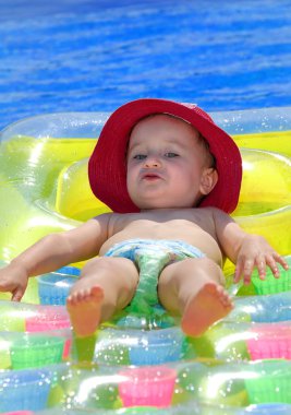 Sevimli küçük sarışın kız bir şişme şişme havuzda yüzen