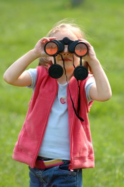 Yeşil alan dürbün seyir üzerinde küçük kız