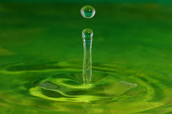 Green water splash. Falling drop of water.