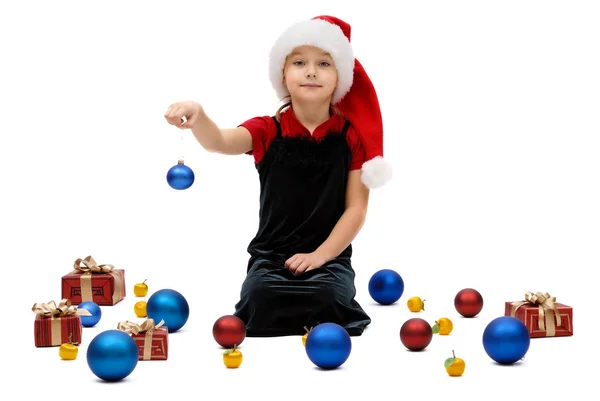 可爱的小女孩在圣诞老人帽与圣诞节小玩意在白色背景 — 图库照片