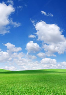 Pastoral bahar manzara, yeşil alanlar, mavi gökyüzü ve beyaz bulutlar arka planda çalışırken