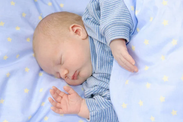 Babyjongen slapen op een witte deken — Stockfoto