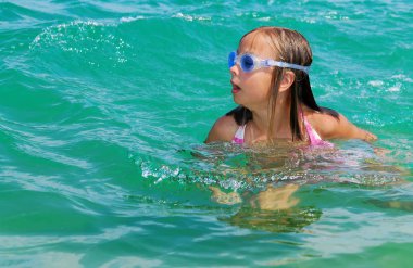 Denizde oynarken gülümseyen sevimli kız