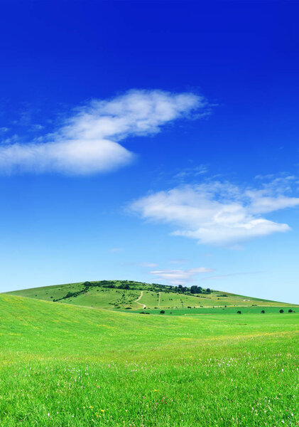 Idyllic view, green hills and blue sky with white clouds