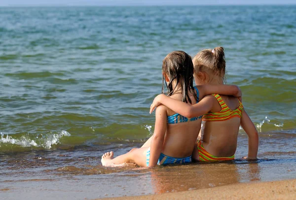 两个女孩坐在海滩上 — 图库照片