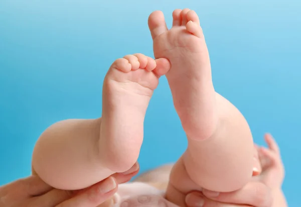 Vrouwelijke palm houden van de voet van een baby — Stockfoto