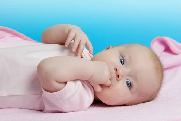 Meisje van de baby liggend op een roze deken — Stockfoto