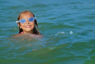 Denizde oynarken gülümseyen sevimli kız