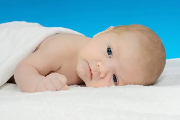 Babyjongen liggend op een witte deken — Stockfoto