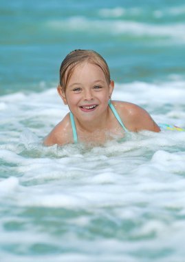 Denizde oynarken gülümseyen sevimli kız