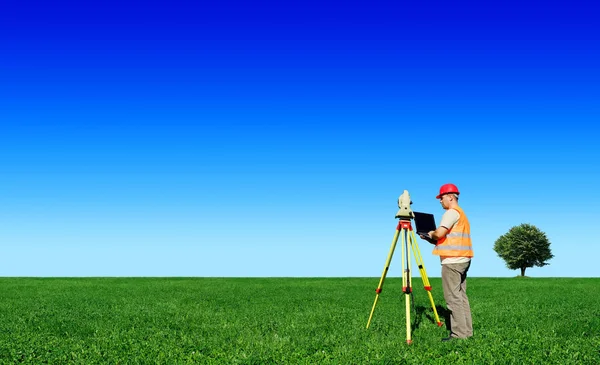 Geodet na zelené louce — Stock fotografie