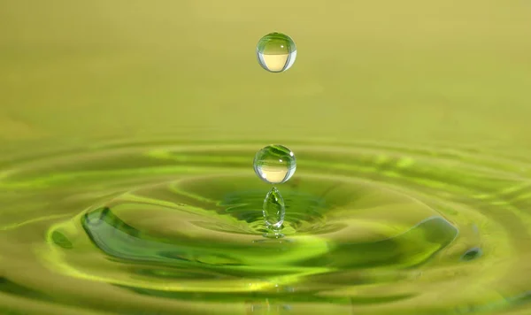 Caduta verde sulla superficie dell'acqua — Foto Stock