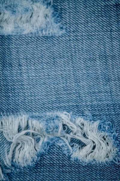 Blue Jean texture with a hole and threads. — Stock Photo, Image