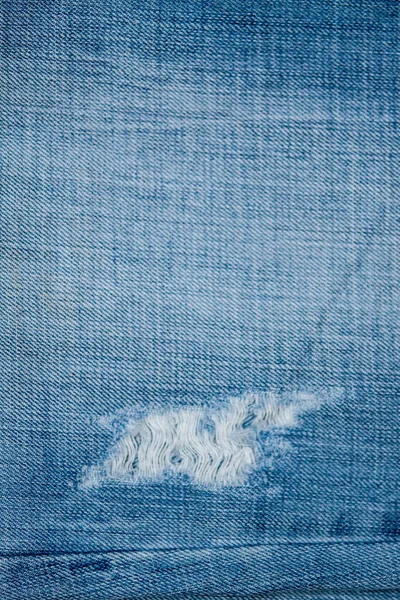 Blue Jean texture with a hole and threads. — Stock Photo, Image