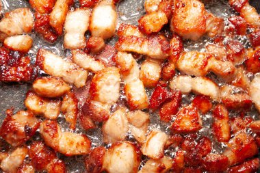 Bir tavada kızartma domuz pastırması doğranmış parçaları