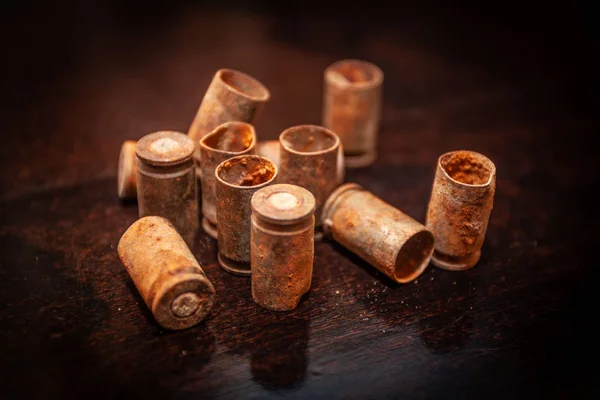 A pile empty bullet shells on a wooden background — Stock Photo, Image