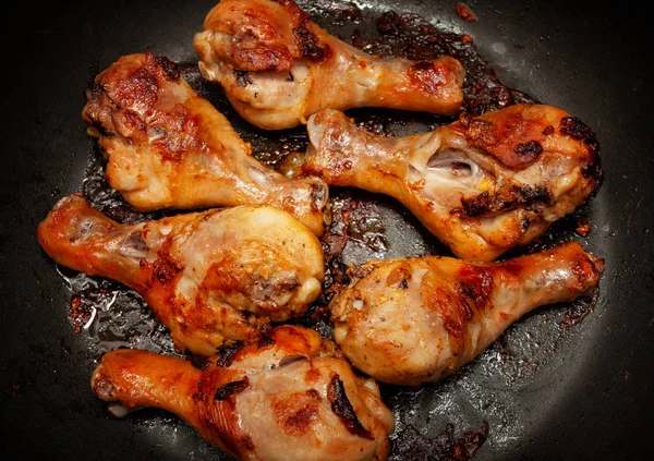 Roasted chicken legs in a black pan — Stock Photo, Image