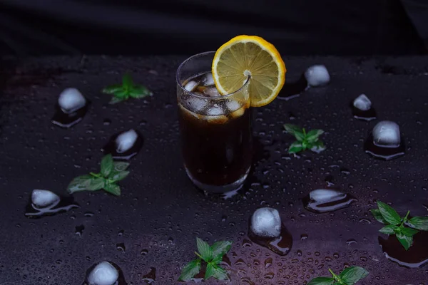  buzlu çay, nane ve limon suyu damla ile koyu arka plan üzerinde