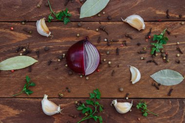  Kırmızı soğan, baharatlı biber, sarımsak, maydanoz ve körfez yaprağı kahverengi ahşap masa manzaralı.