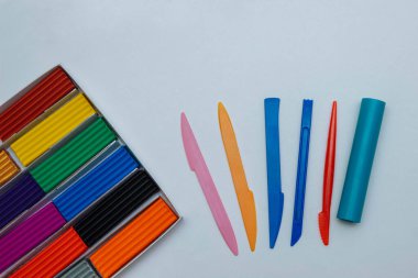 Kutuda çok renkli modelleme killeri ve beyaz arkaplan görünümlü plastik araçlar ile metin, kontsptiya snovav okulu, çocukların gelişimi ve iyi motor becerileri, sanat için boş bir alan