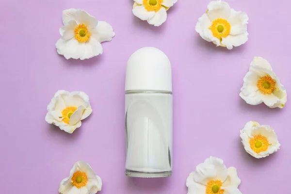 Pembe arka plan görünümlü beyaz orkide çiçekli patenli deodorant şişesi, kişisel hijyen konsepti, ter koruması, kozmetik ve dermatoloji, taze koku..