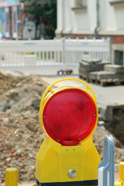 road under construction with signal lamps and construction fence