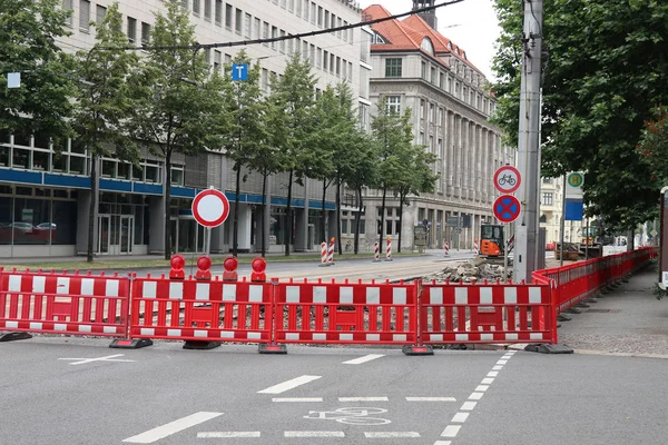 road under construction with signal lamps and construction fence