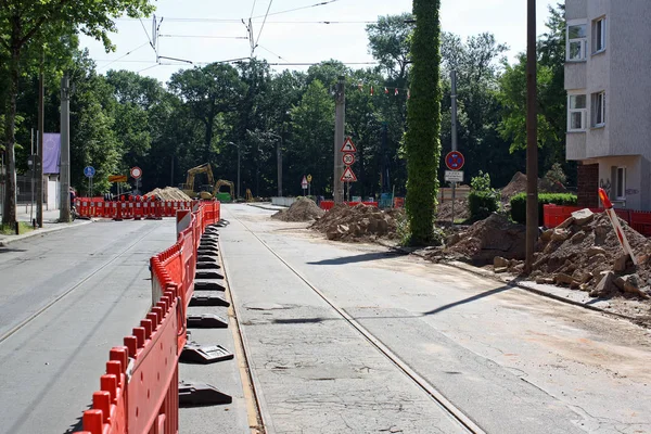 road under construction with signal lamps and construction fence