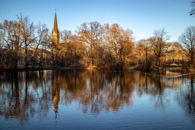 Gölet Park Romantik köprüler, Leipzig kış mavi gökyüzü ile kilise ile