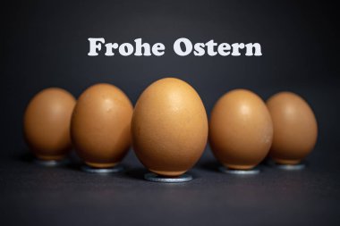 Siyah arka plan karşı Paskalya için düzenleme birkaç yumurta. Mutlu Paskalya Almanca metinle.