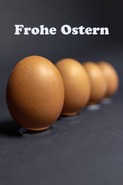 Siyah arka plan karşı Paskalya için düzenleme birkaç yumurta. Mutlu Paskalya Almanca metinle.
