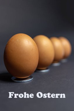 Siyah arka plan karşı Paskalya için düzenleme birkaç yumurta. Mutlu Paskalya Almanca metinle.
