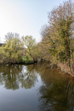 Ağaçlar, köprüler ve mavi gökyüzünde bir weir ile Leipzig nehir 