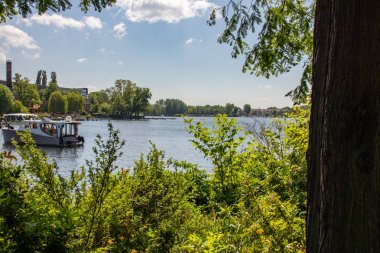 Berlin Koepenick'te, kıyıda evleri, köprüleri, gemileri ve tekneleri ile Dahme ve Spree nehrinin romantik manzaraları