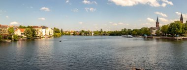 Berlin Koepenick'te, kıyıda evleri, köprüleri, gemileri ve tekneleri ile Dahme ve Spree nehrinin romantik manzaraları